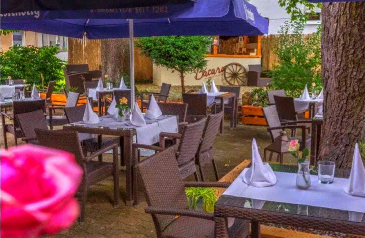 Terrasse des Ristorante Kaiserhof mit gedeckten Tischen im Grünen